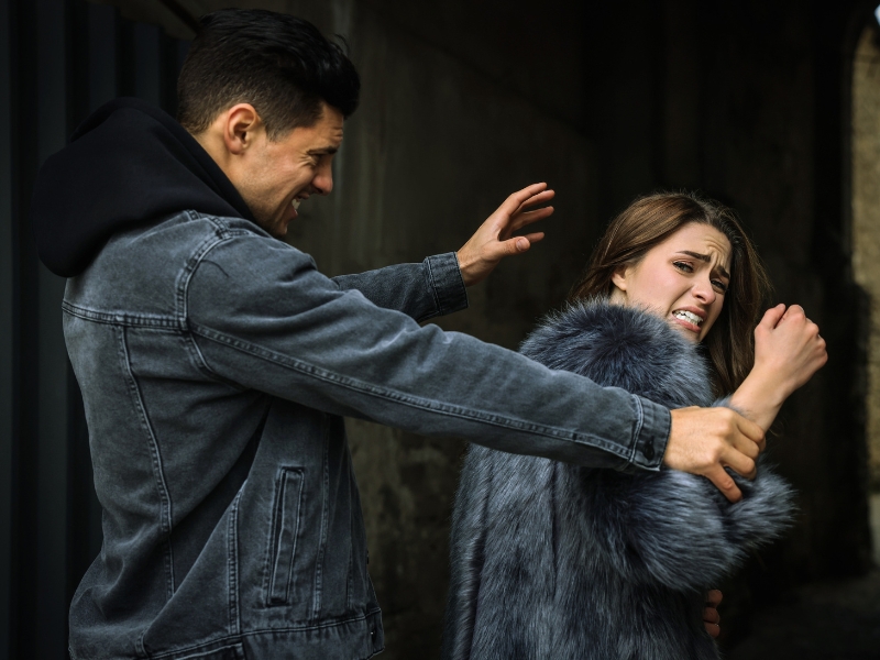 Criminal attacking young woman in alley