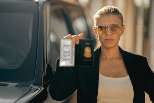 Special federal intelligence agent woman in black suit and big police car