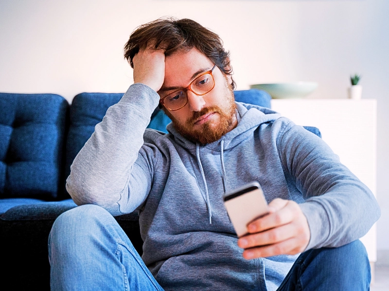 Single lonesome guy checking cell on the couch. text messages in Minnesota drug cases