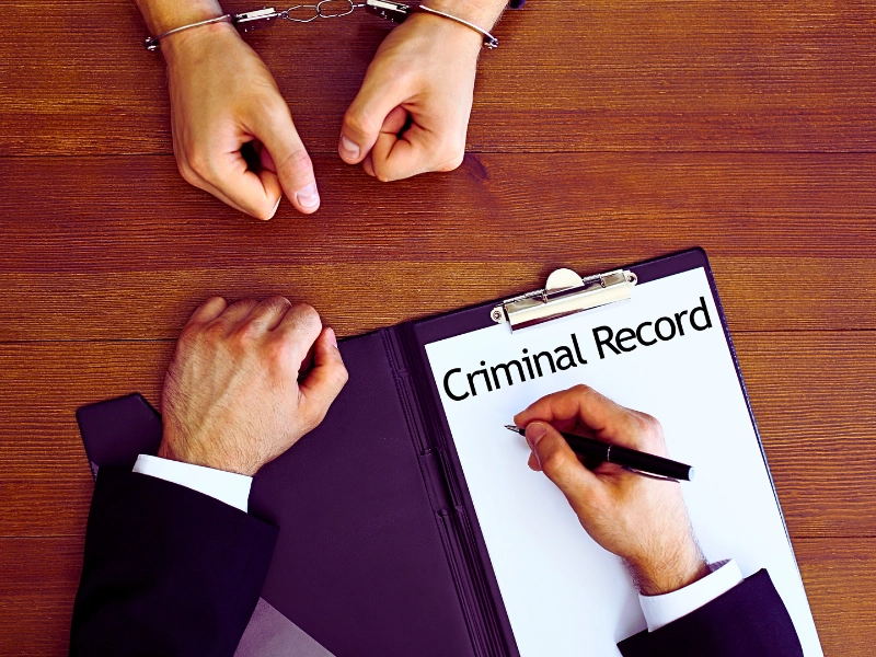 Top view police officer examining criminal record at desk. criminal record impact new charges