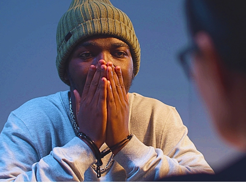 Handcuffed man in beanie looking distressed during interrogation. police lie to you during an interrogation