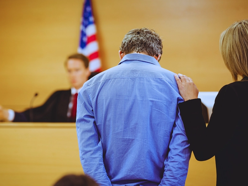 A man on blue shirt with his lawyer facing the judge. Your First Court Date in Minnesota