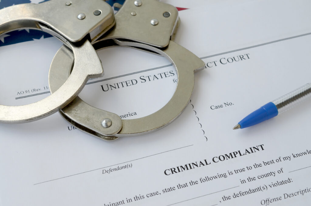 district court criminal complaint-court papers with-handcuffs blue pen united states flag