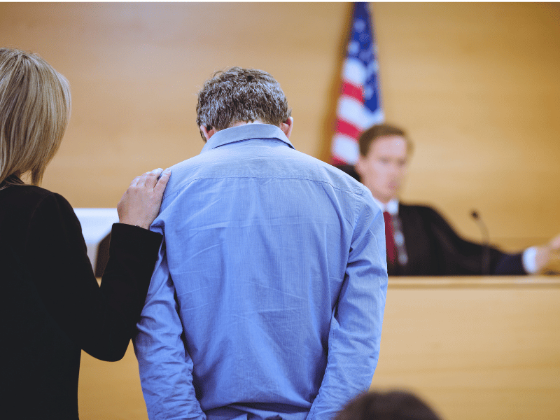 Scene from a criminal defense case, with a lawyer defending the accused before the judge.
